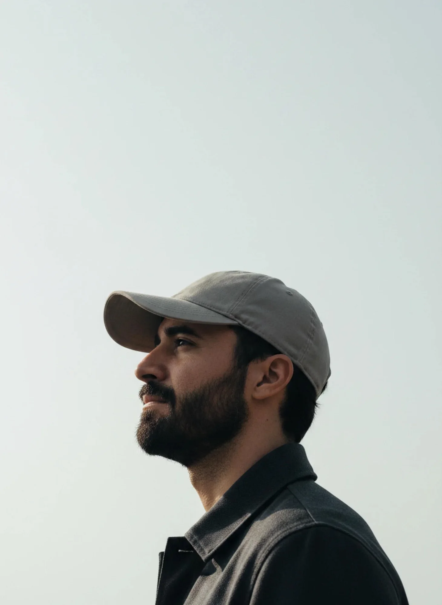 Diego, in a grey cap, looking up at a pale sky